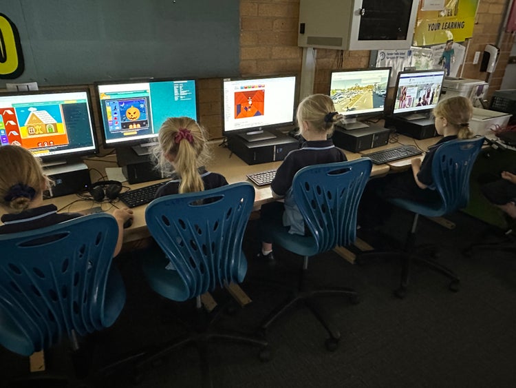 Four students working on computers in the computer lab