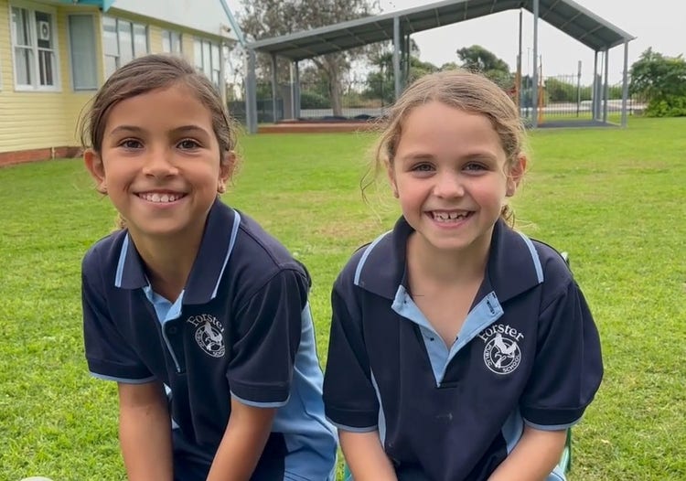 two girls smiling in the school playground
