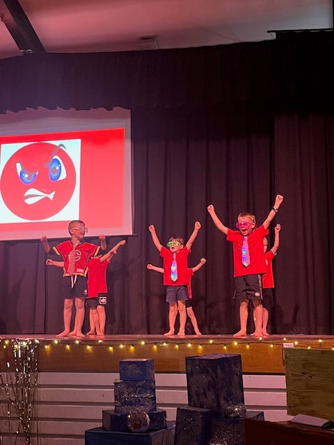 six students on stage performing in a concert