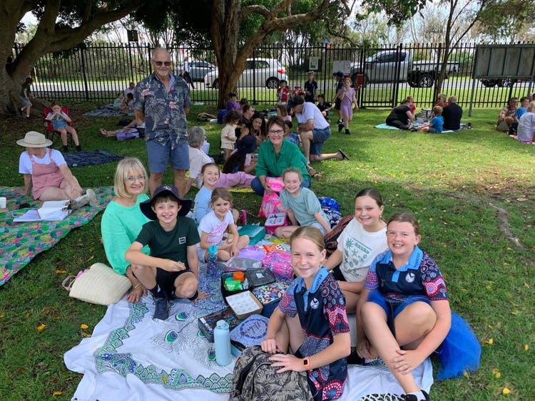grandparents enjoying picnic with students on lawn