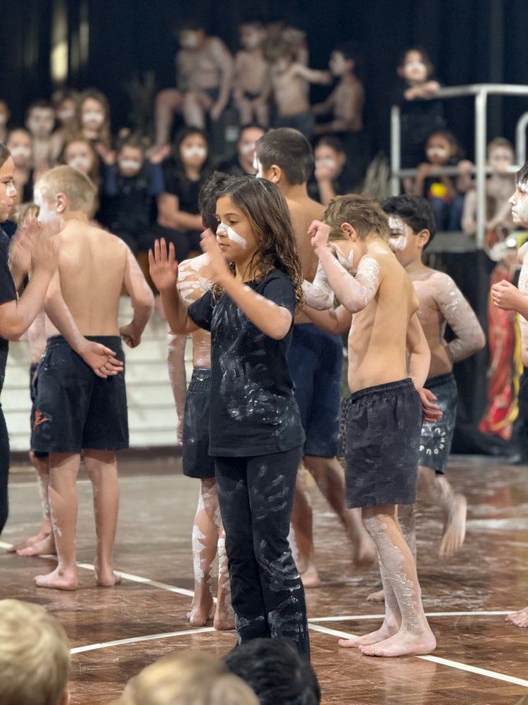 aboriginal girl dancing amongst other aboriginal students