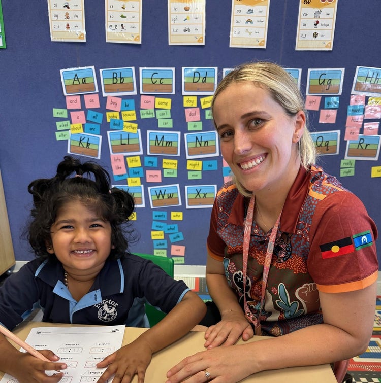 teacher helping student with a work book