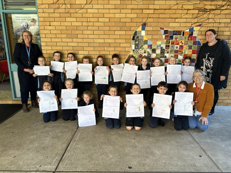 class of students showing their work with the principals